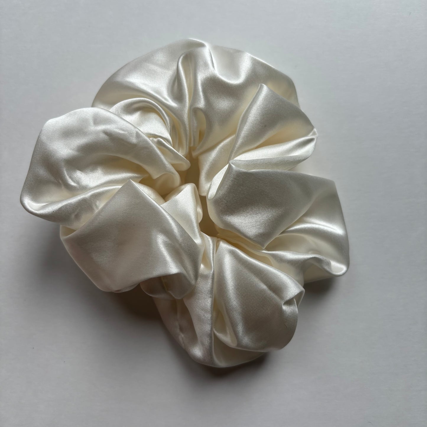 Curlora silk scrunchie for natural hair in pearl white on marble surface